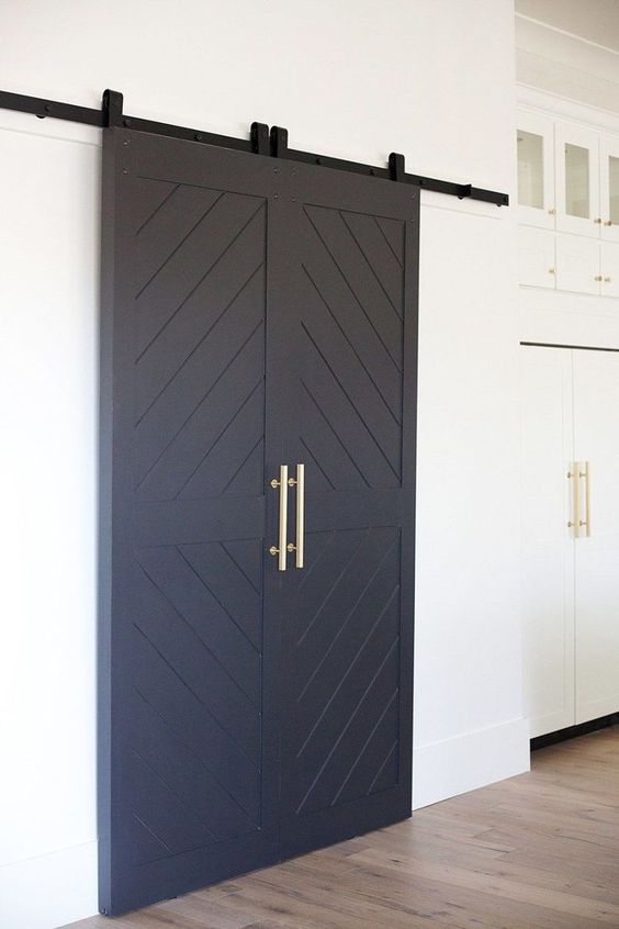 navy sliding barn doors with gold handles will bring a slight barn feel to the space and rustic touch