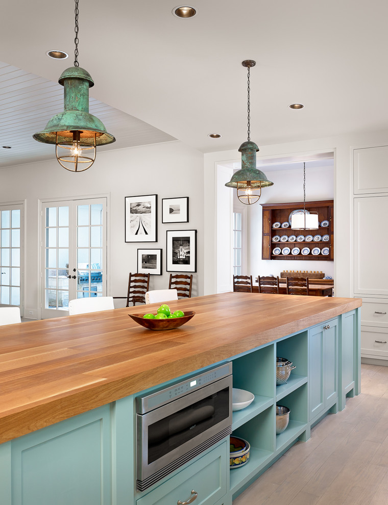 Turquoise kitchen island with a butcher countertop and a built-in microwave. (Dillon Kyle Architects (DKA))