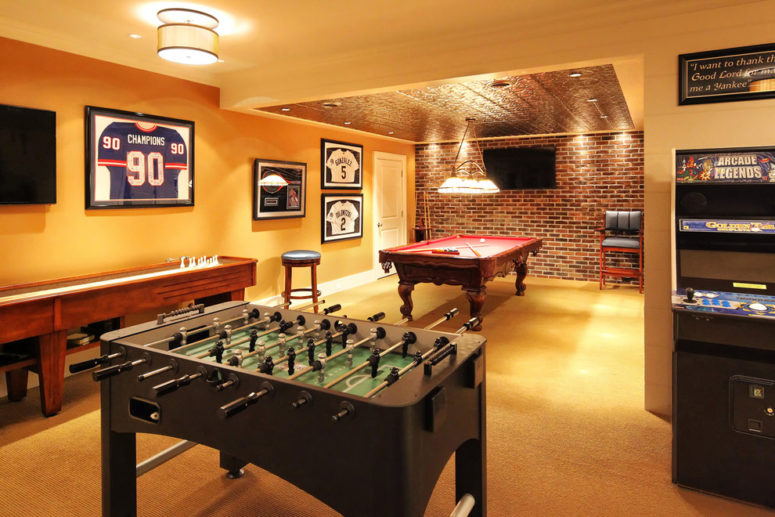 a pinball machine, a pool table and a football table are an ultimate combo for a game area (Knight Architects LLC)
