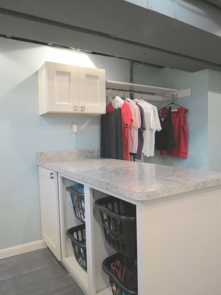 If your laundry room is in a basement provide enough storage for laundry baskets, hanging clothes and for other cleaning supplies. Countertop surface is also a must. (Woodmaster Kitchens)