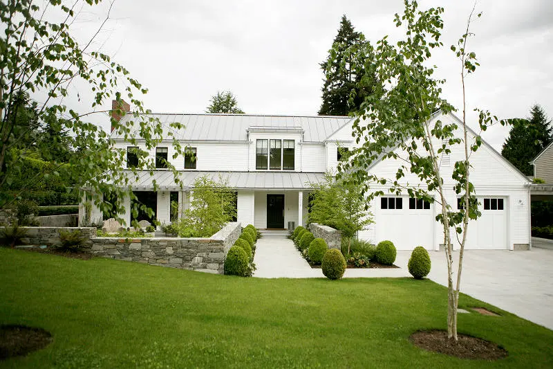 The crisp white house looks so inviting amidst the green shrubs