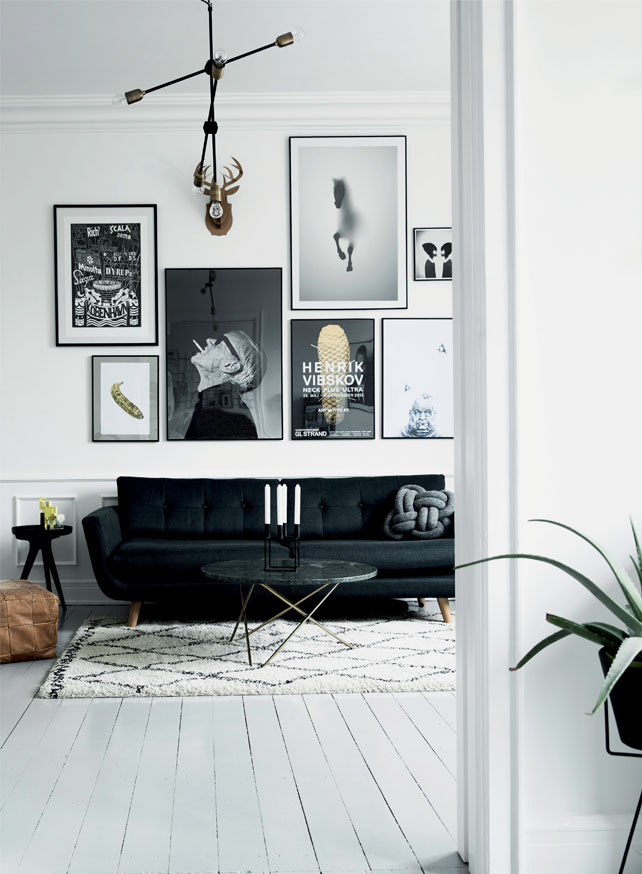The living room in black and white is made cozier with the help of a cool rug and pillow