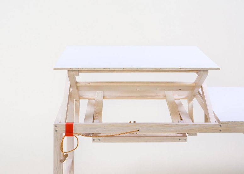 This adjus.table is made of light colored wood and can be regulated manually