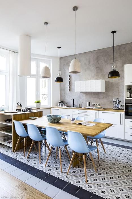 The kitchen is simply white, with light colored wood countertops and light blue chairs