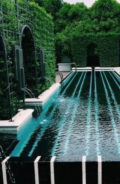 pool surrounded by tall hedges and greenery