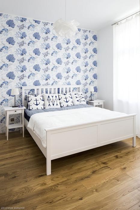 The master bedroom is decorated with white IKEA pieces and an accent wall with blue coral print