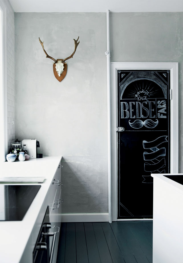 A chalkboard door makes the kitchen more relaxed and let you not take the monochrome interior too seriously