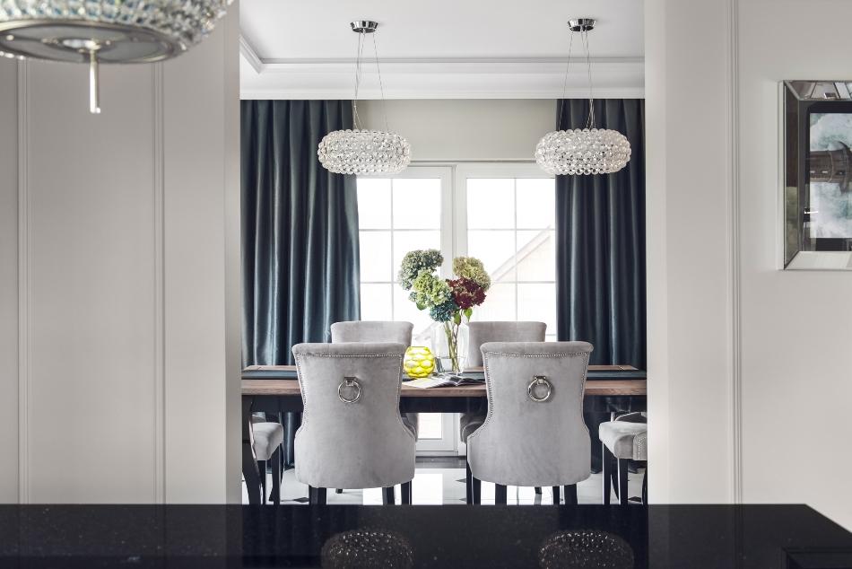 The dining space continues the decor theme with rhienstone lamps and chic upholstered chairs