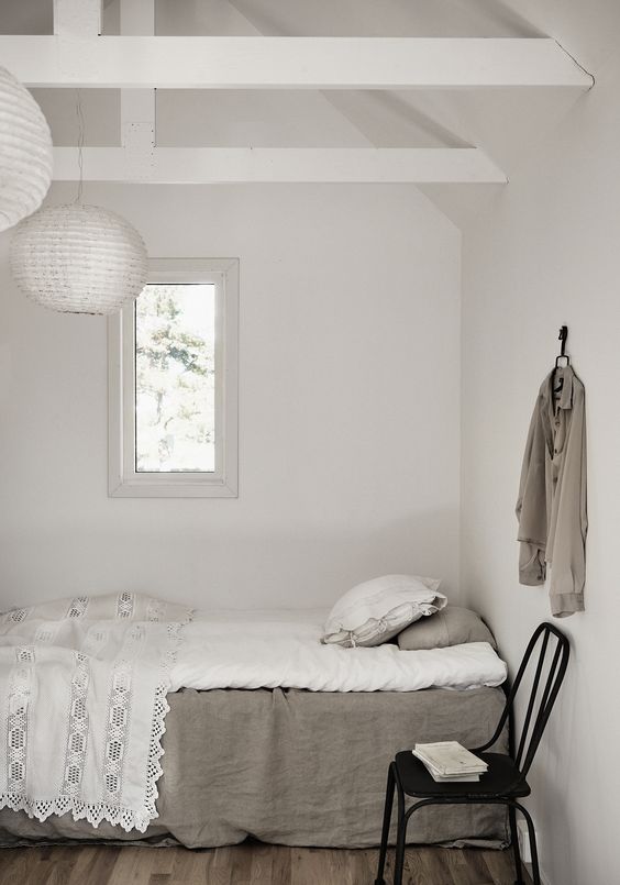 The guest bedroom is all-white, only the floors are wooden