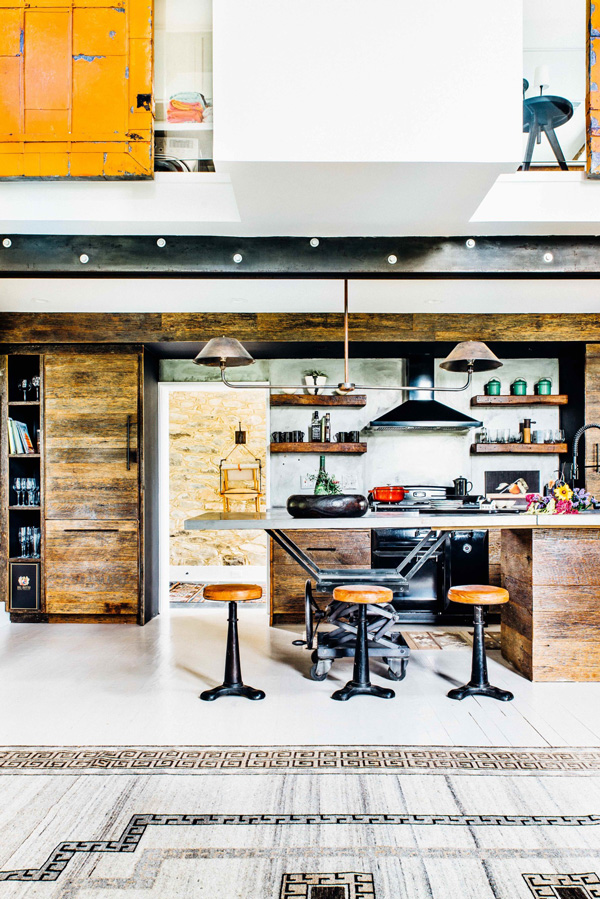 The kitchen is totally industrial, decorated with blackened steel and reclaimed wood