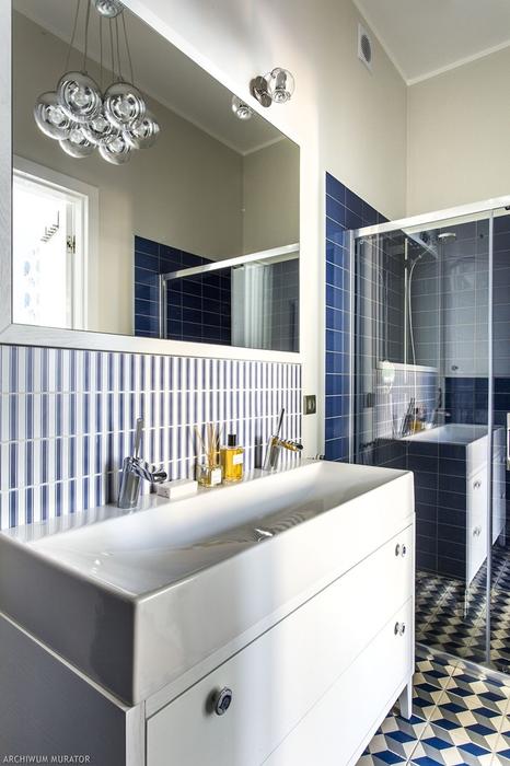 The bathroom is decorated in shades of blue, with 3D floor tiles and a bauble lamp