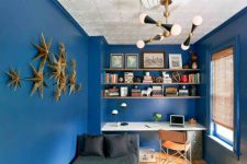 07 The home office is dazzlign blue with a cool lamp and a 3D wall art