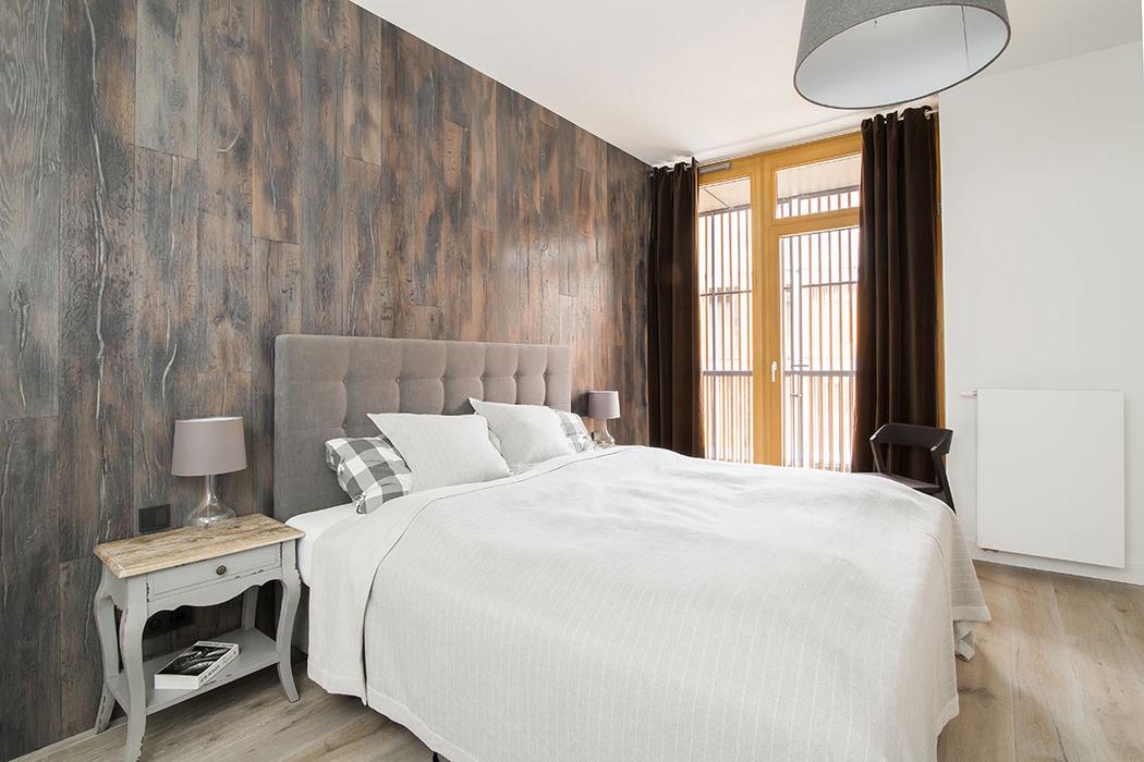 The master bedroom is covered with various types of wood to achieve a soothing ambience