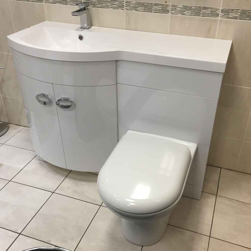 curvy sink with a countertop and a toilet