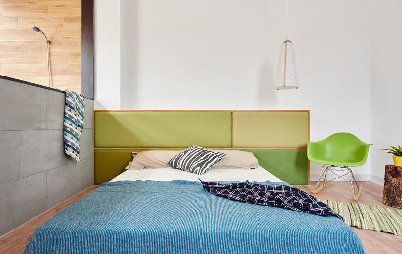 08 the master bedroom can boast of several bold touches like a green headboard and chair and a blue bedspread