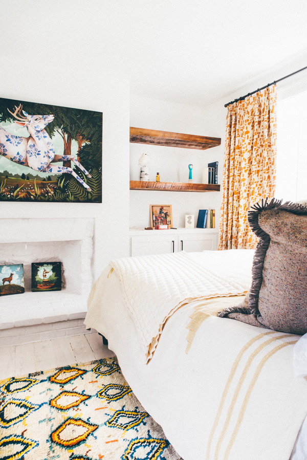 The second bedroom is decorated with warm-colored textiles and animal artwork
