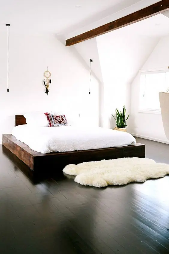 polished black wood floors for an all-white bedroom