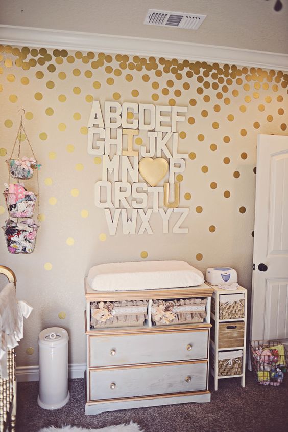 white and gold changing table with a cool alphabet art over it