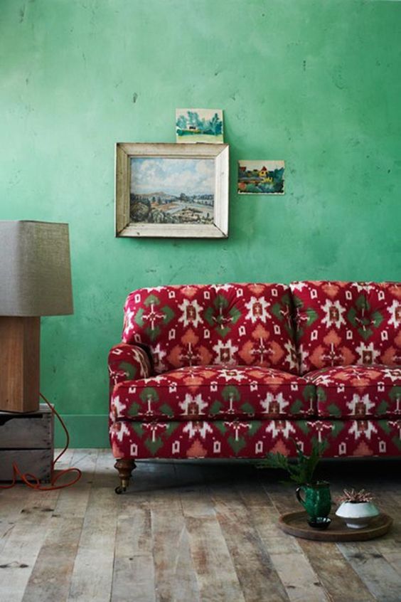 Light green walls and a red vintage sofa