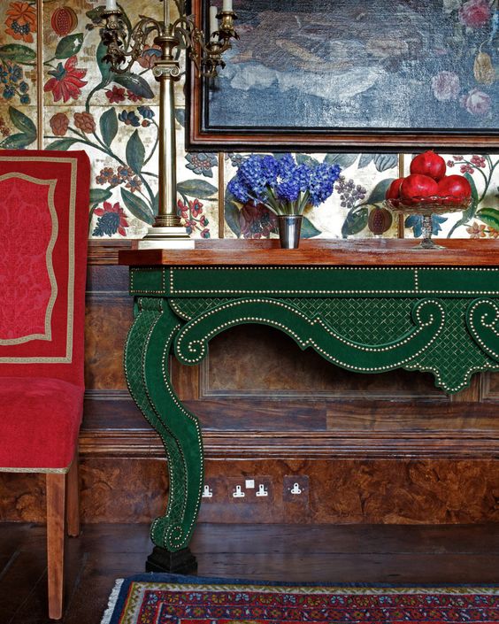 Red upholstered chair and an emerald console table