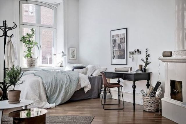 Scandinavian bedroom with a black desk by the fireplace