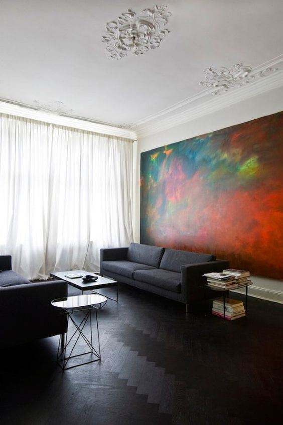 dark wood herringbone floors and charcoal grey sofas show off the oversized art piece