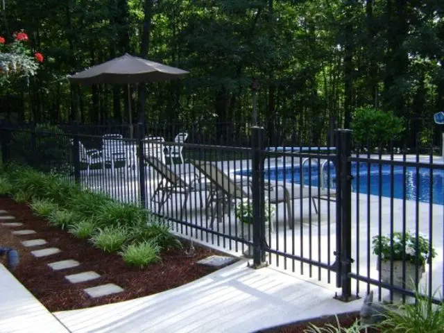 22 blackened steel pool fence with flower beds around