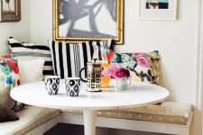 a colorful glam breakfast nook with lots of patterns, a round table and a whimsical gallery wall for a touch of fun