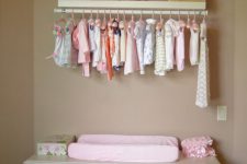 26 pastel changing area with a cloth organizer made of simple curtain rod