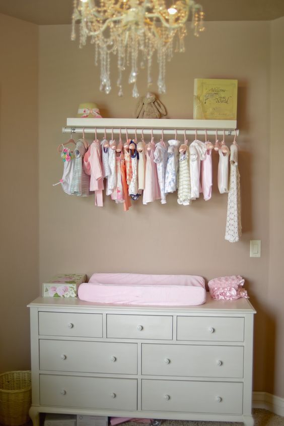 pastel changing area with a cloth organizer made of simple curtain rod