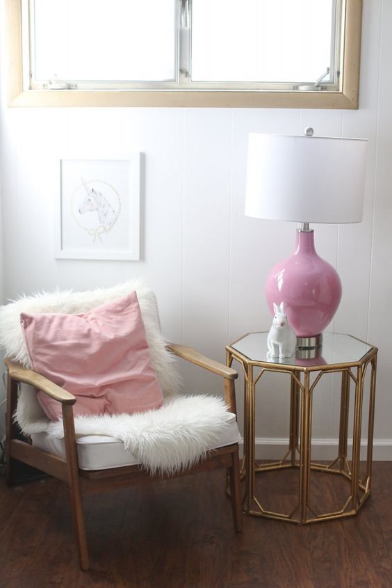 glam nursery seating area with a fur cover and a pink lamp