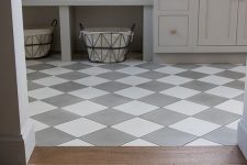 a checked tile floor and a laminate floor with a boundary of wood look quite cohesive and stylish