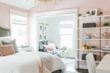 a chic bedroom with pink walls,a grey bed with neutral bedding, a shelving unit, a white desk and a chair, a glam chandelier