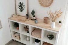 a chic boho storage unit of an IKEa Kallax shelf, with wooden boxes and some lovely decor on top is amazing