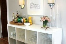 a chic home bar of an IKEA Kallax unit placed on legs features much storage space