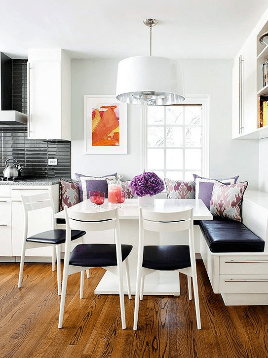 a little lively nook with a corner seating and a square table plus chairs, colorful pillows for a vivacious feel