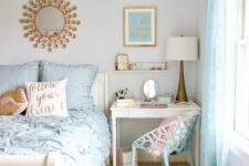 a lovely bedroom with a small desk and a blue chair, a neutral bed with blue bedding, some cool decor and brass touches