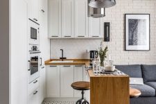 a modern white kitchen with shaker cabinets, a counter kitchen island, a polka dot floor and laminate, a pendant lamp