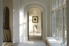 a refined space with arched doorways and a floor transition from tiles to laminate is a very cool and cozy idea