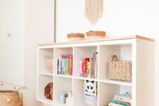 a simple and cool storage unit for a kids’ room made of an IKEA Kallax piece with a wooden countertop and wooden legs