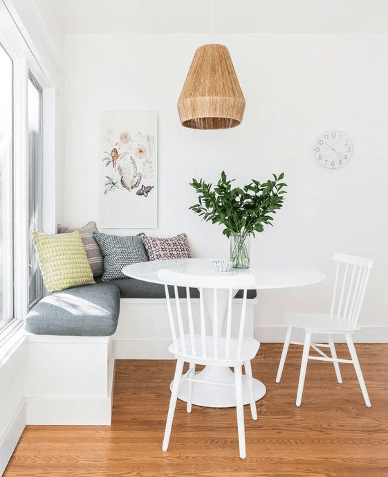 a simple and cute breakfast nook with an upholstered bench, a round table and chairs