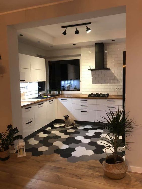 a white Scandinavian kitchen with butcherblock countertops, a white subway tile backsplash, a monochromatic hex tile floor and laminate