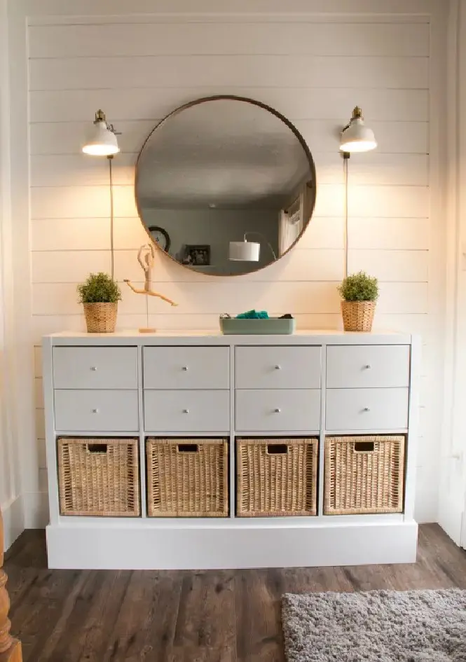 a white storage unit or console of an IKEA Kallax piece with woven basket drawers and usual ones