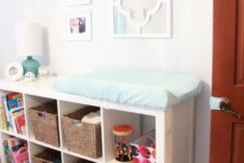 an IKEA Expedit storage unit with open storage spaces and baskets as a changing table and a storage piece in one