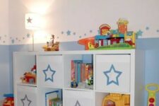 an IKEA Kallax shelf with Drona boxes finished with pretty stars is a lovely idea for a kids’ room, it will provide you with storage
