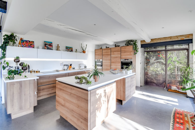 polished concrete grey flooring on a spacious kitchen with wooden cabinets (JACQUES AGRAFFEIL- MAÎTRISE D‘ŒUVRE)