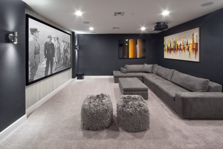 a home theater with a gray sectional couch and a gray carpet that reflect less light than white ones (Morrone Interiors)