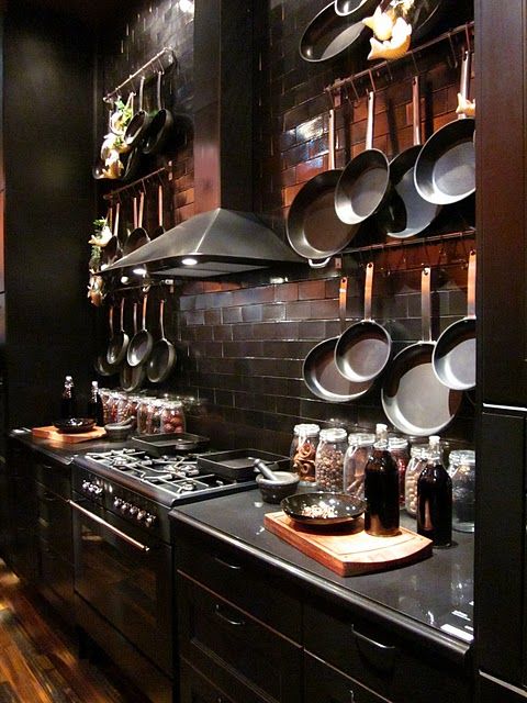 moody black kitchen with reddish tiles backsplash