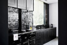 wooden black kitchen with a brick backsplash and a glass hood