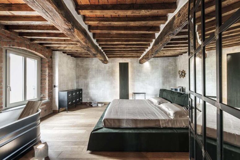 The master bedroom boasts of original ceilings with wooden beams and industrial touches